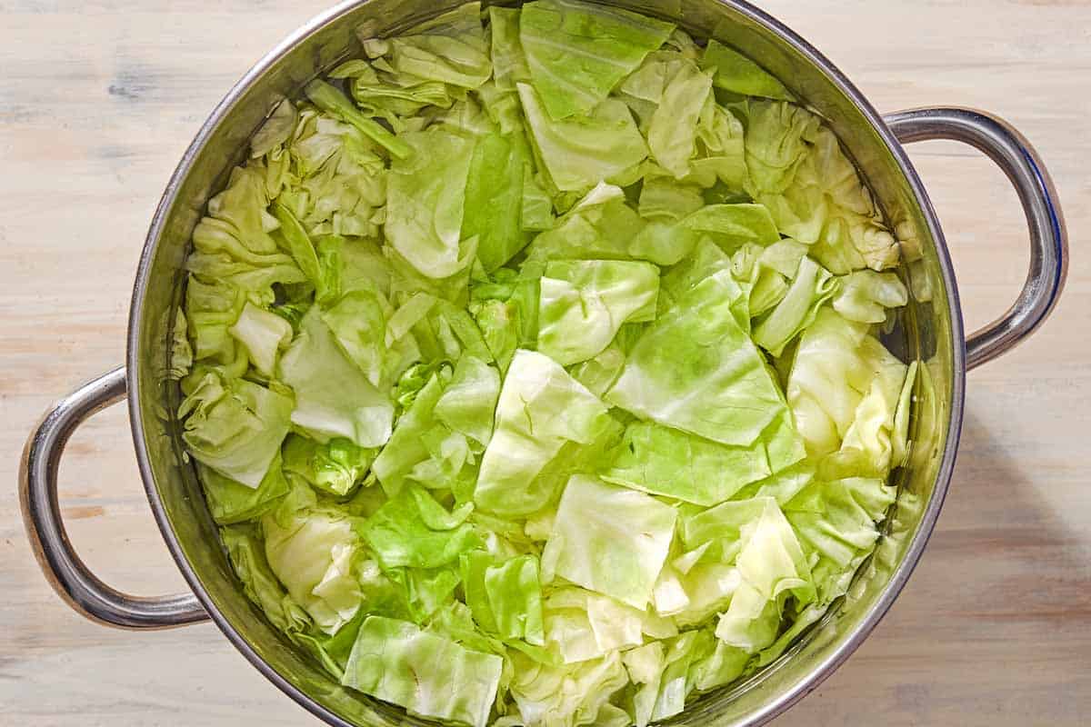 An overhead photo of cabbage cooking in a large pot of water.