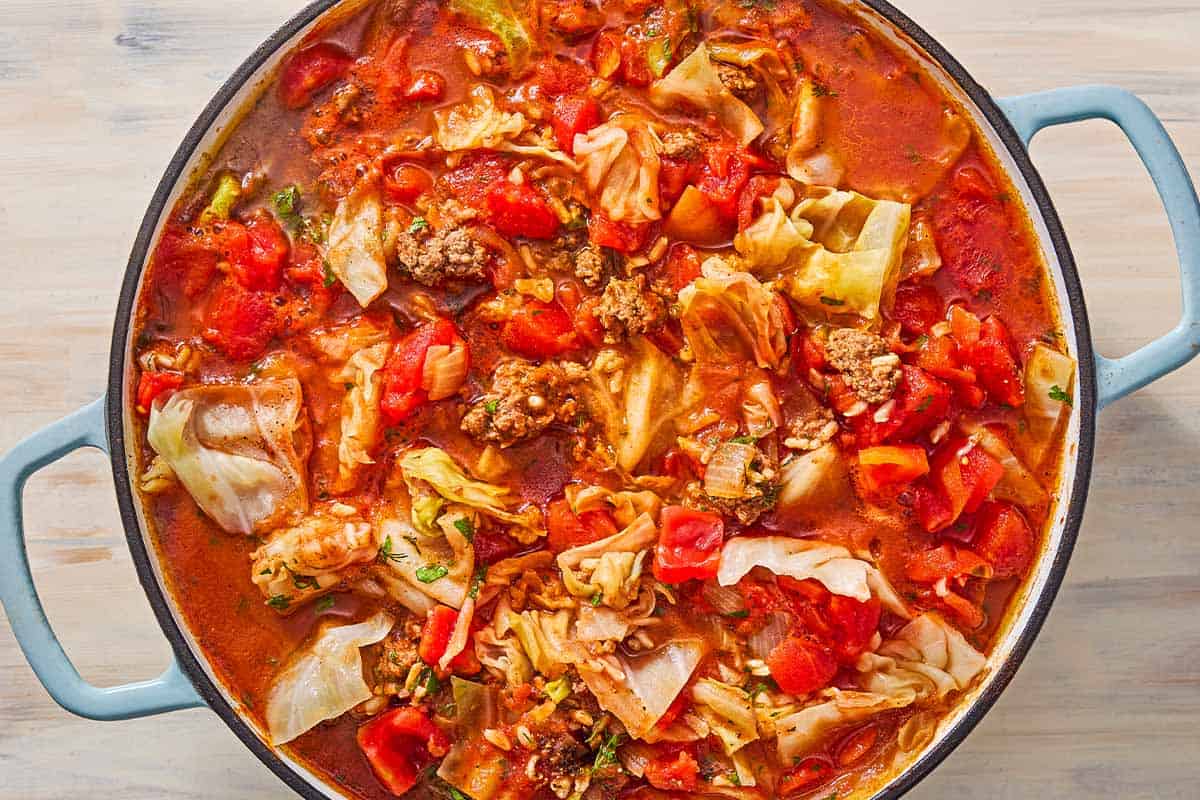 An overhead photo of unstuffed cabbage rolls cooking in a skillet.