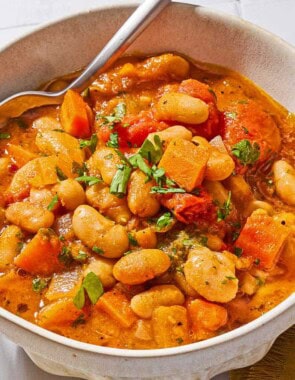 White bean stew in a bowl with a spoon.