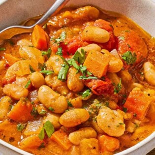 White bean stew in a bowl with a spoon.