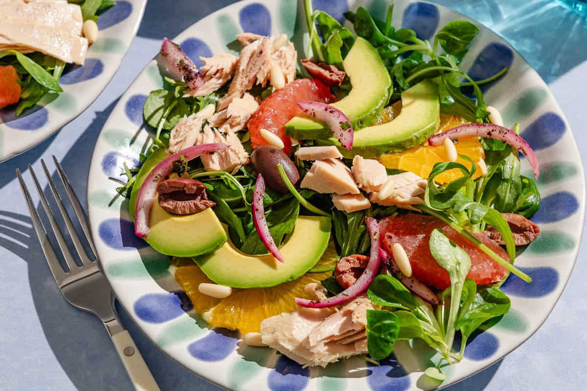 Avocado tuna salad on a plate with a fork next to it.