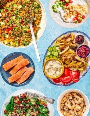 An image of various forms of essential Mediterranean diet proteins including bean and lentil salads, salmon, shrimp, chicken and yogurt.