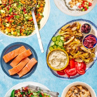 An image of various forms of essential Mediterranean diet proteins including bean and lentil salads, salmon, shrimp, chicken and yogurt.