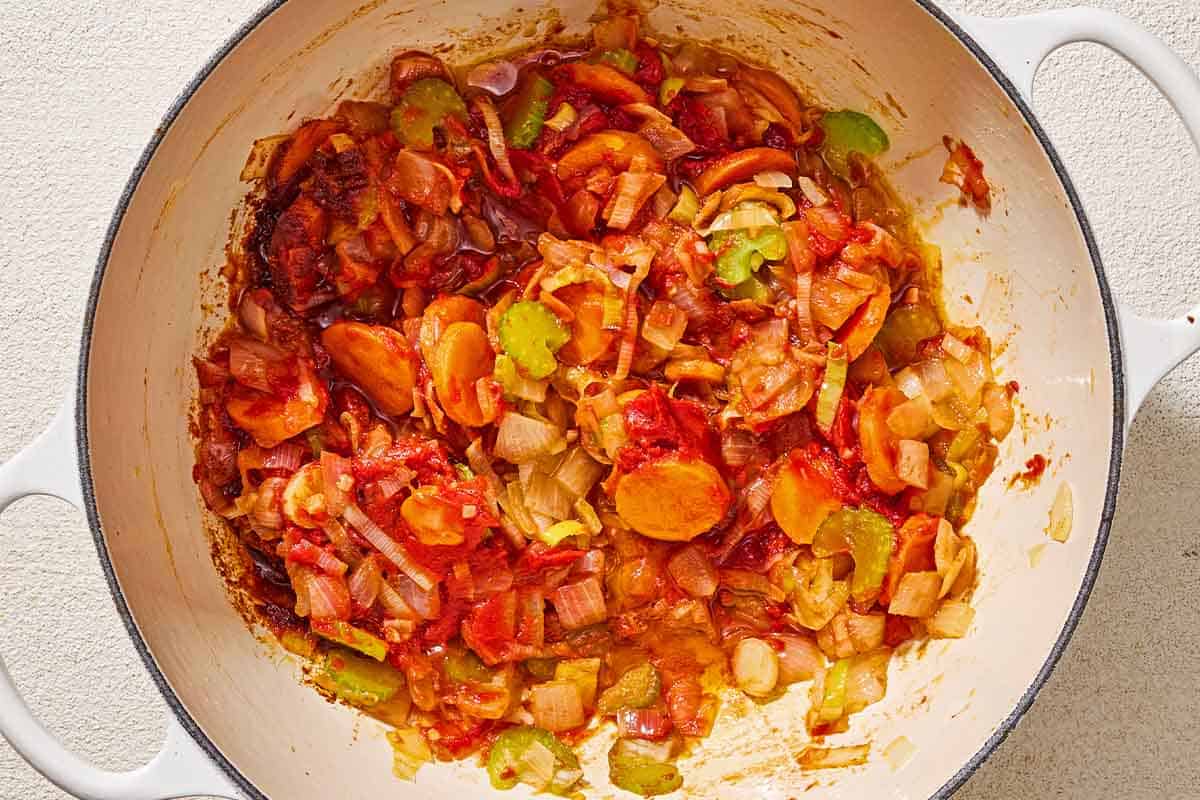 The vegetables for the greek cabbage rice being sauteed with tomato paste in a large pot.