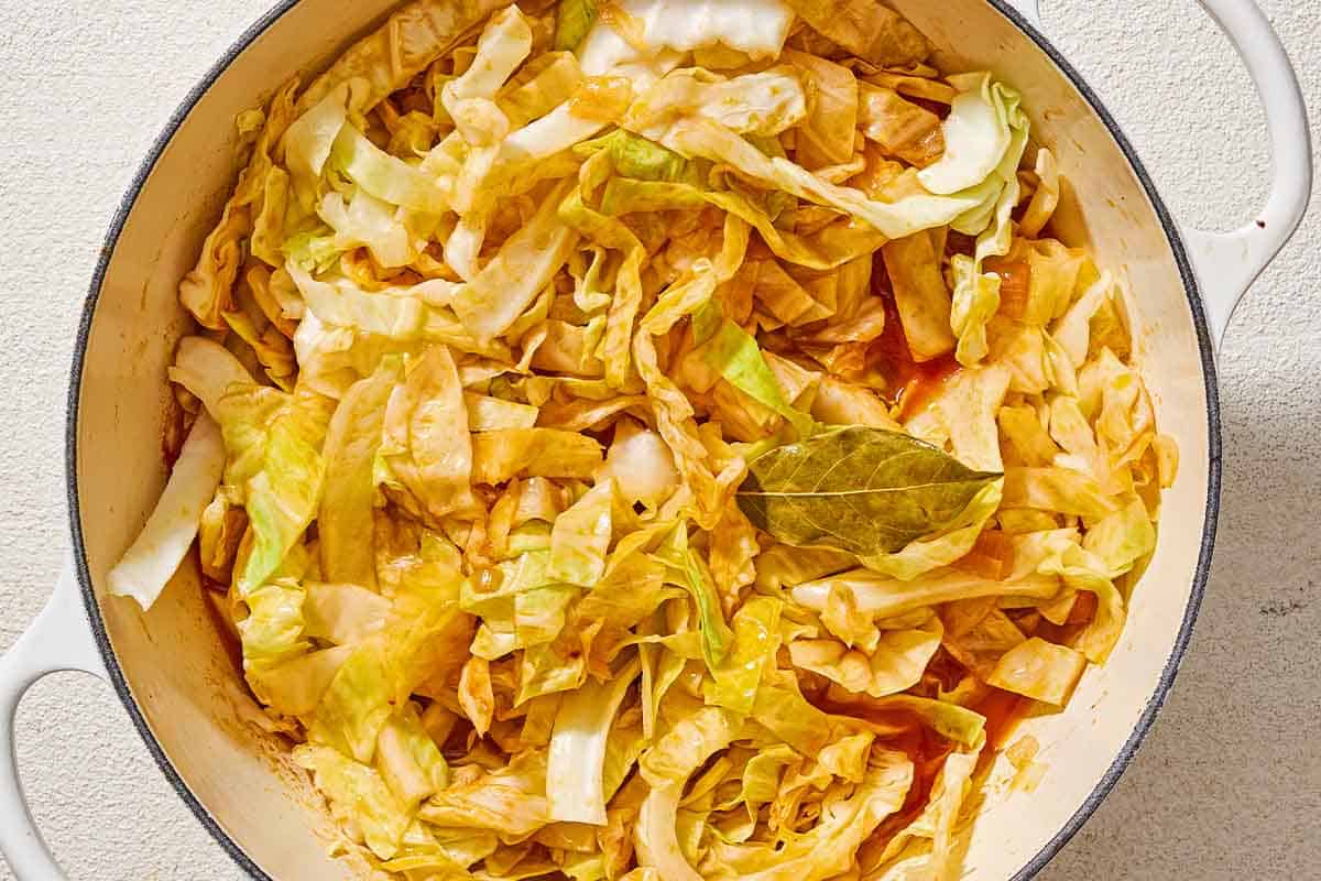 Sliced cabbage cooking in a large pot.