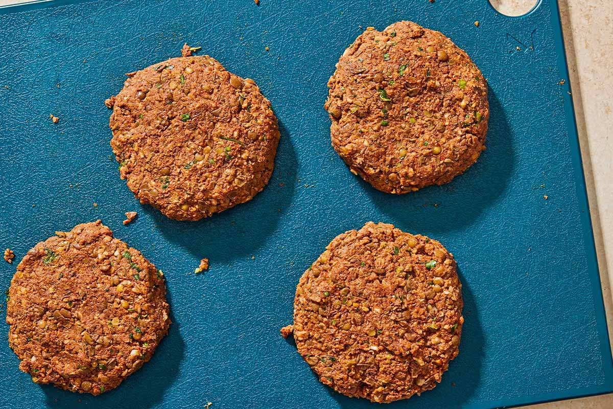 4 Lentil burgers on a cutting board.