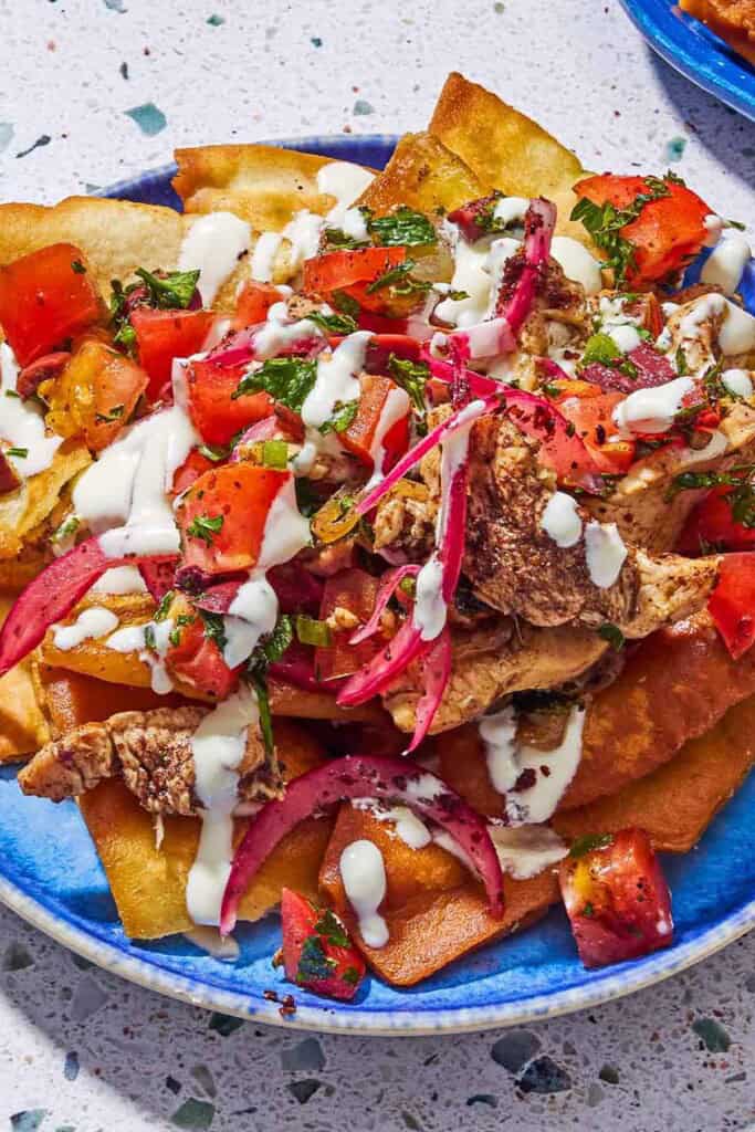 A serving of chicken nachos on a plate.