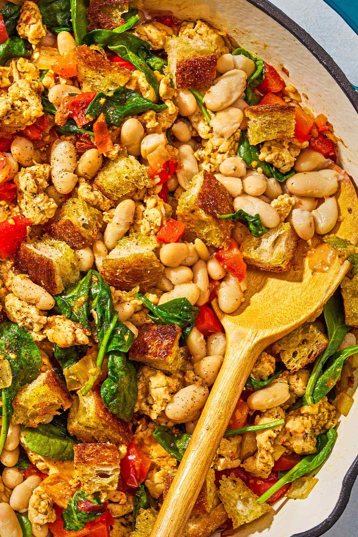 The ground turkey dinner in a skillet with a wooden spoon.