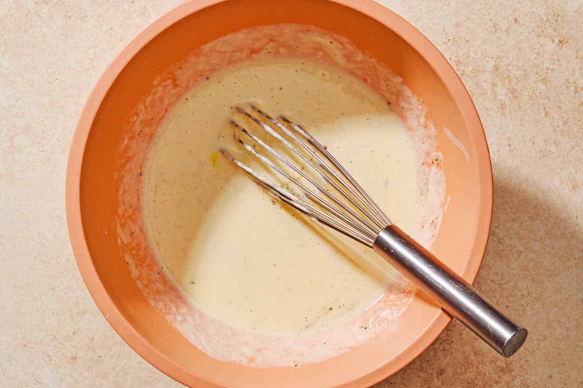 The yogurt sauce for the turkish meatballs in a bowl with a whisk.