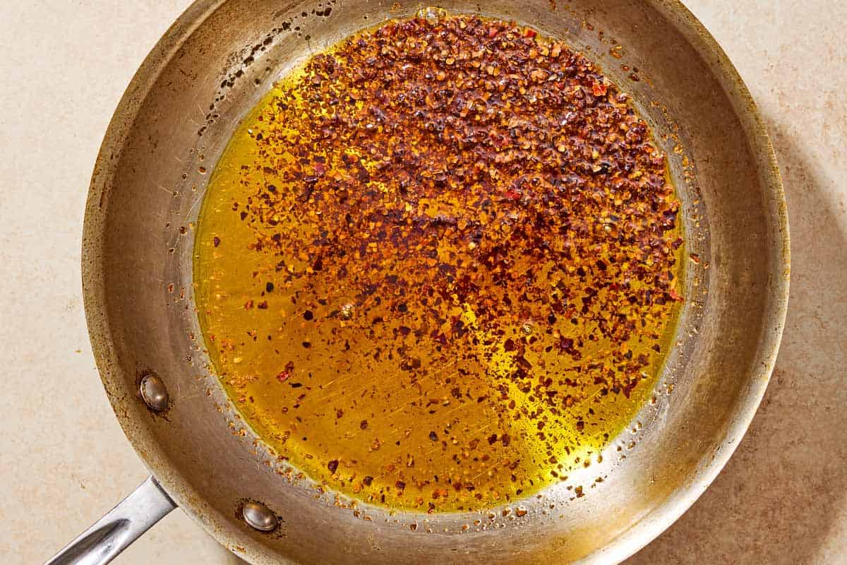 Aleppo pepper spiced olive oil in a skillet.