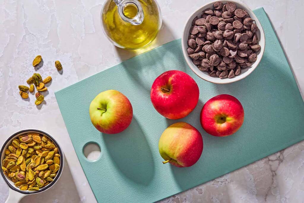 Ingredients for vegan chocolate mouse including apples, pistachios, chocolate and olive oil.