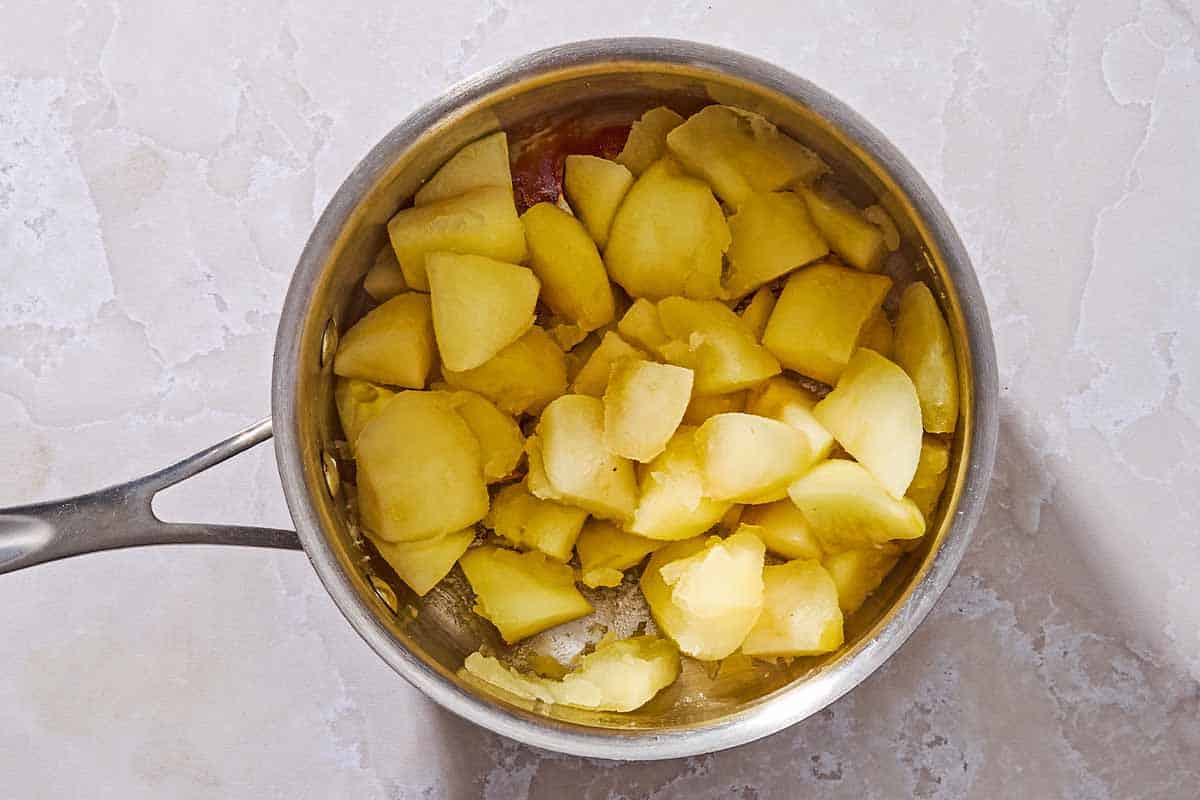 Cooked apple chunks in a saucepan.