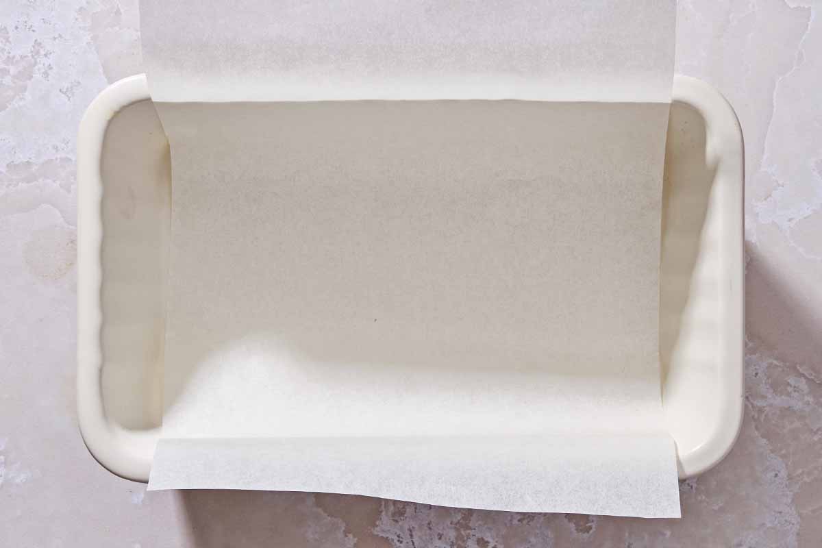 A sheet of parchment paper lining a loaf pan.