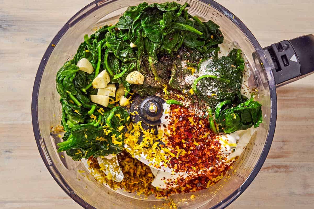 The ingredients for the spinach dip recipe just before being mixed together in the bowl of a food processor fitted with a blade.